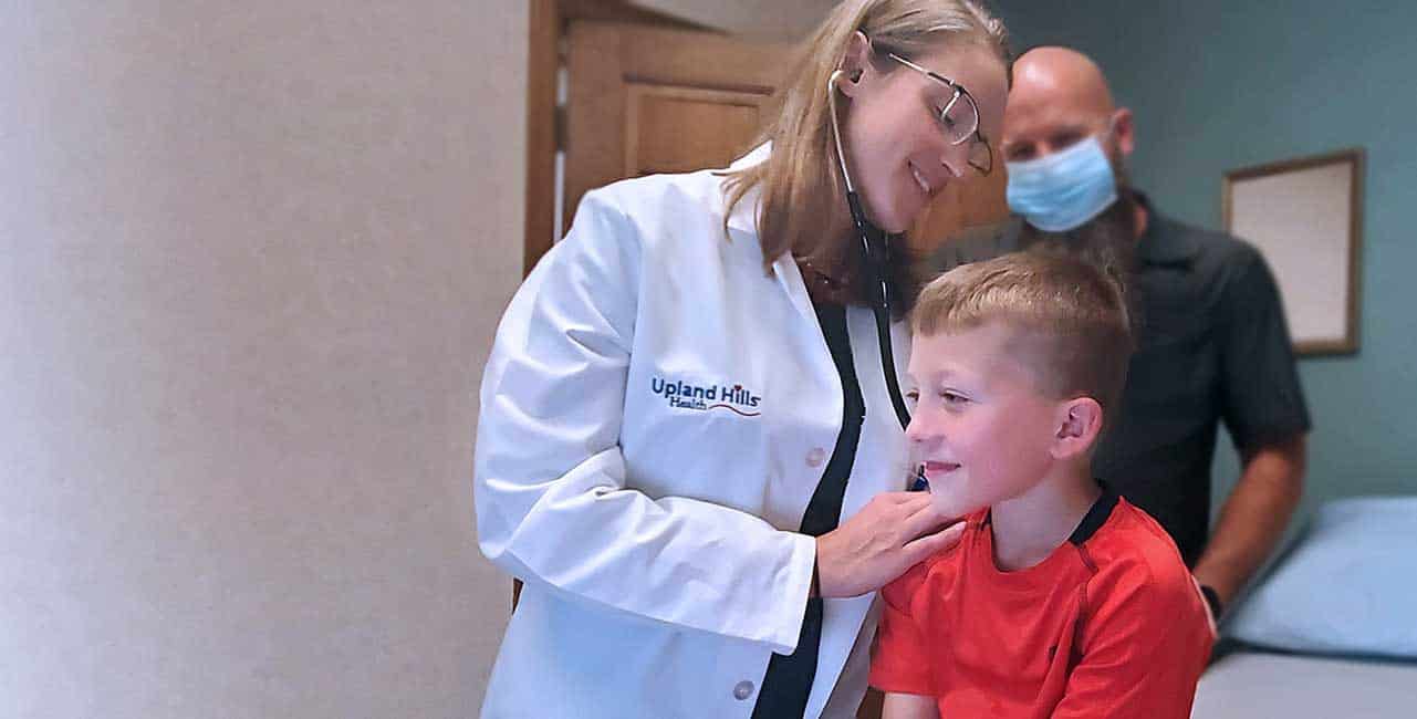 Family Medicine Doctor Sarah Schaaf examines young boy